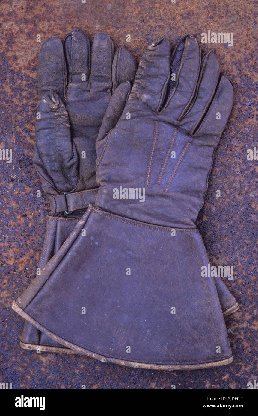Rusty Gauntlet Pair of vintage brown leather gauntlets or large gloves lying on rusty ...