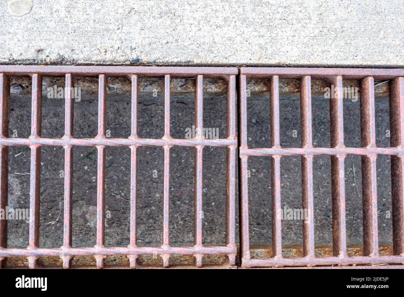 Grate over a stormwater trench in a concrete slab.  Stock Photo