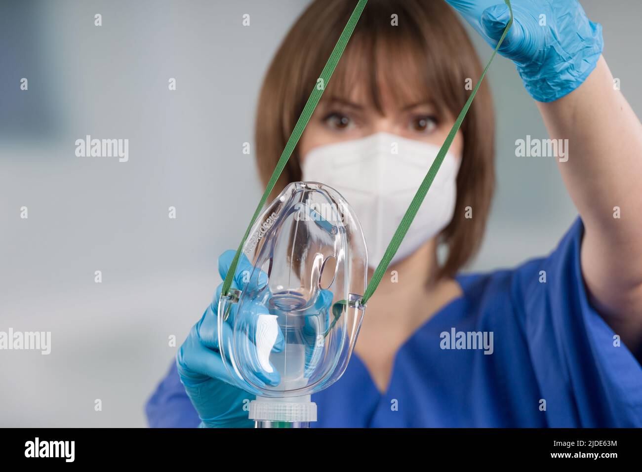 nurse is applying disposable oxygen mask for breathing support from patient view Stock Photo