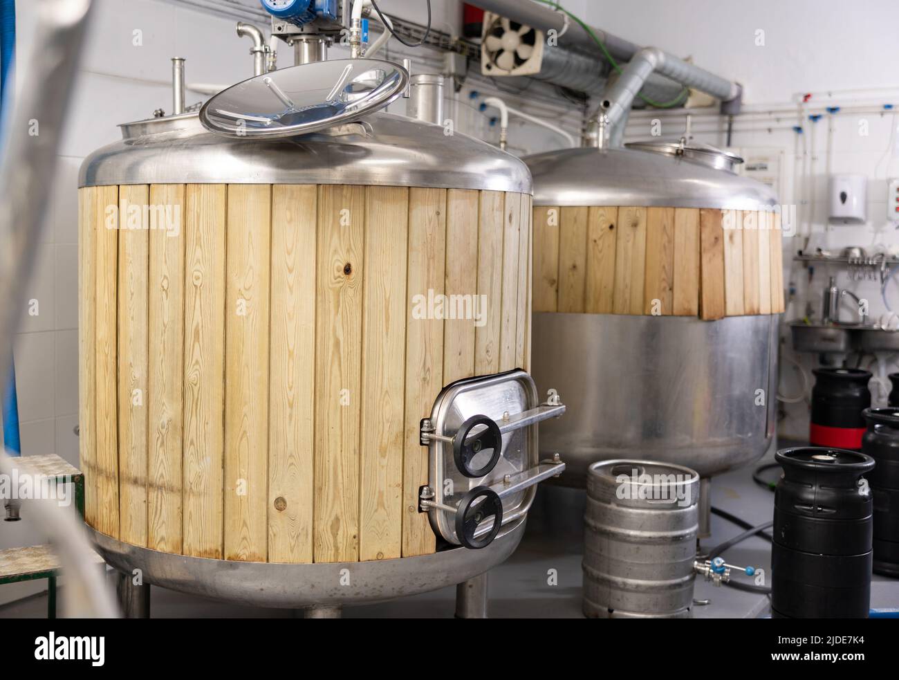 Steel fermenters with wood trim and kegs in brewery Stock Photo Alamy