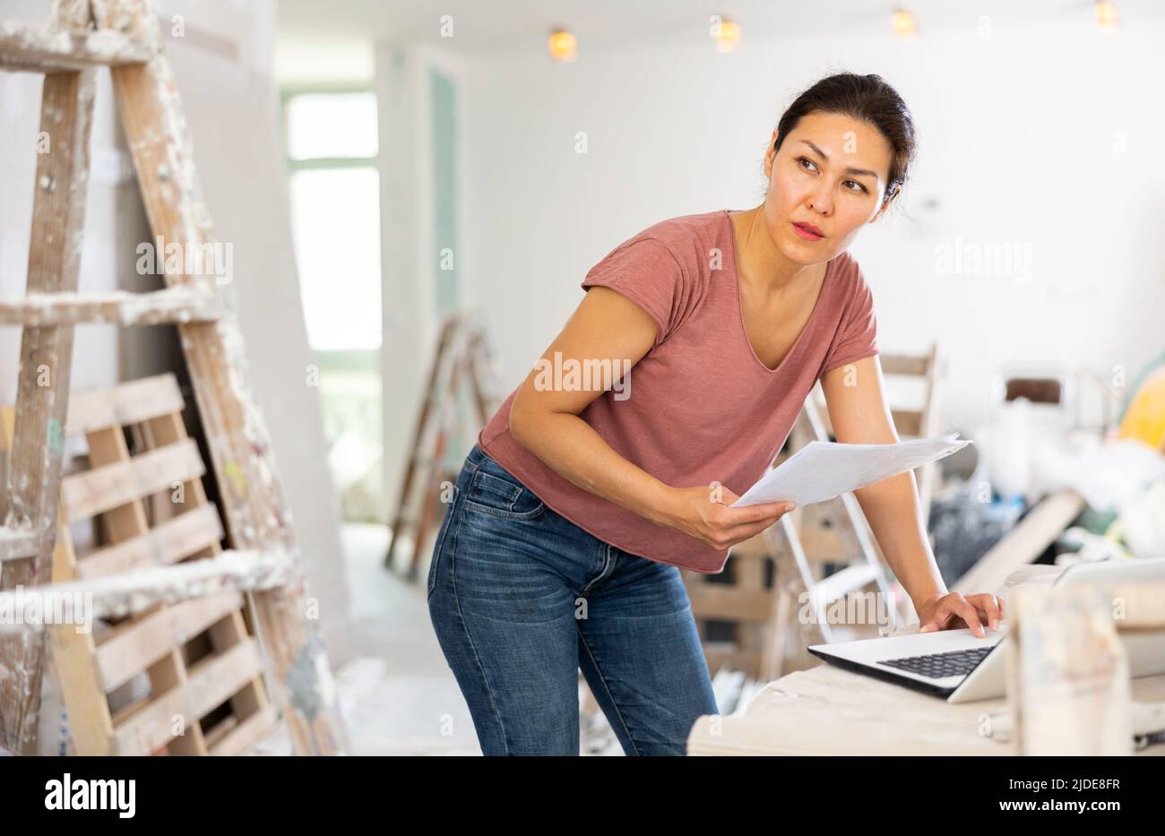 Female architect using laptop during repair works Stock Photo