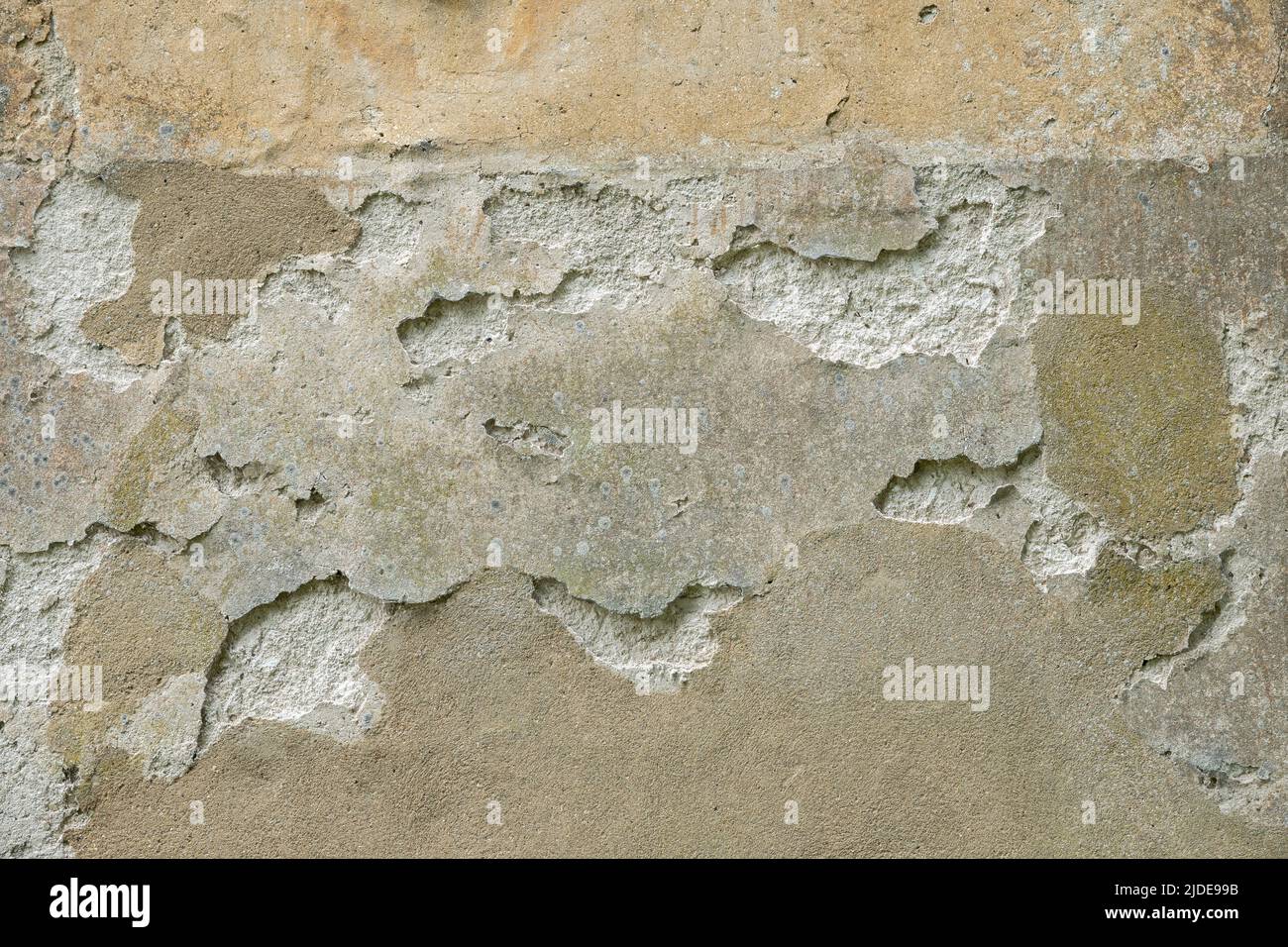 Small area of heavily flaking plaster on a stone wall Stock Photo