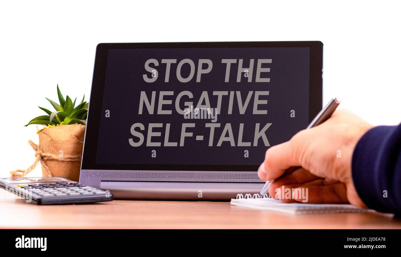 Stop negative self-talk symbol. Concept words Stop the negative self-talk on the black tablet. Businessman hand with pen. Psychological and stop negat Stock Photo