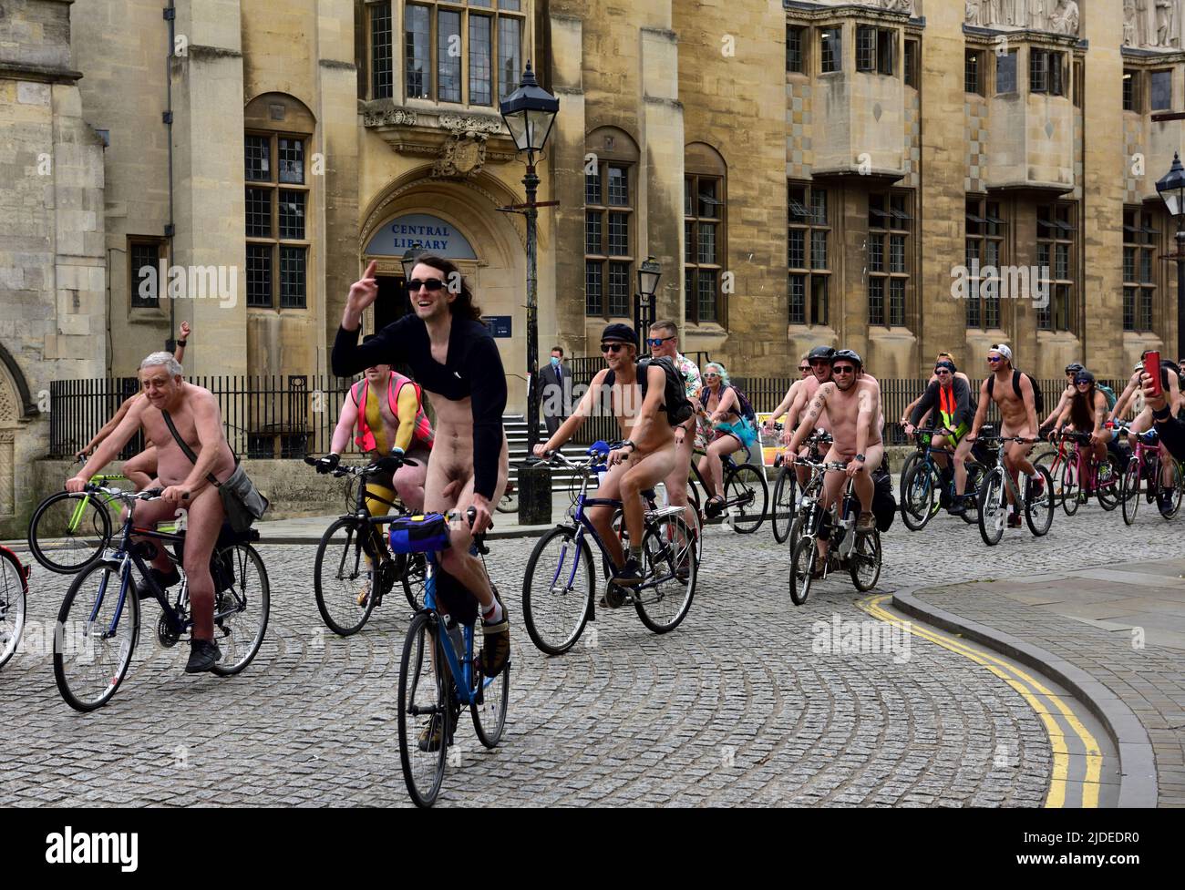 Cyclists in World Naked Bike Ride in Bristol 2022 cycling through the city centre by central library, UK Stock Photo