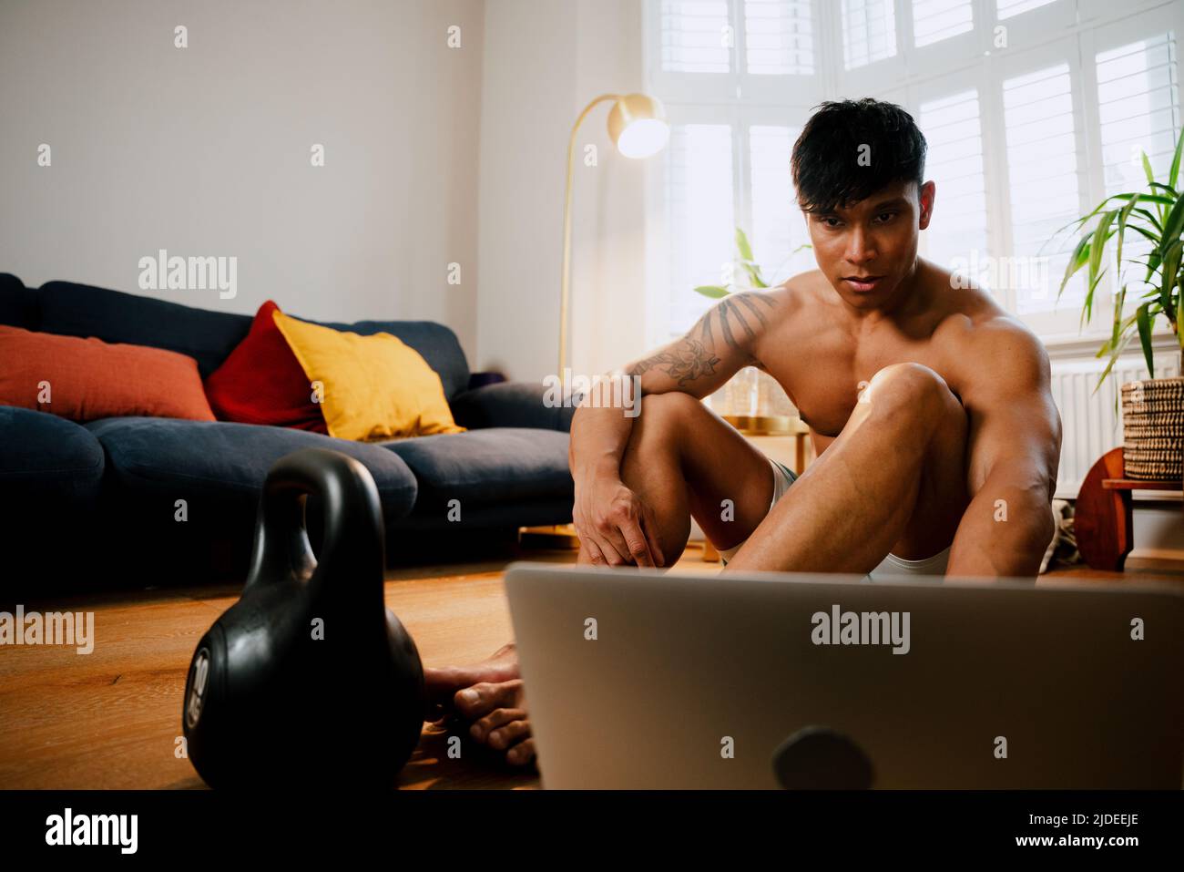 Young Asian male watching fitness program Stock Photo