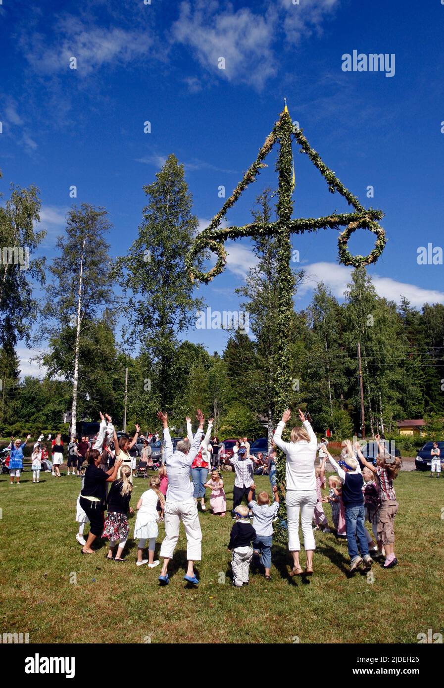 Raising and dancing around a maypole during a midsummer celebration in