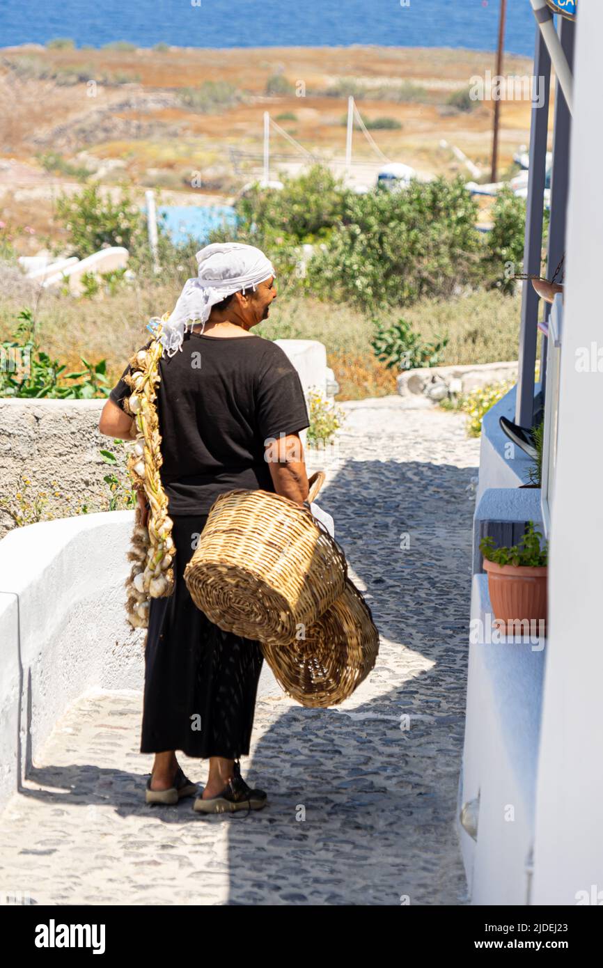 An old lady selling garlic from door to door in Oia Stock Photo
