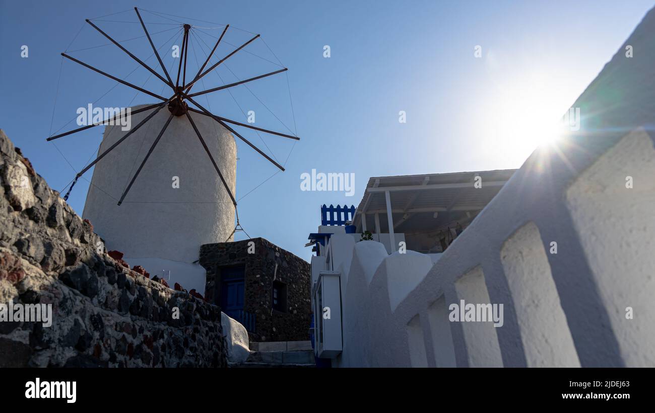 A view of Oia's iconic windmill with sun rays and lens flares Stock Photo