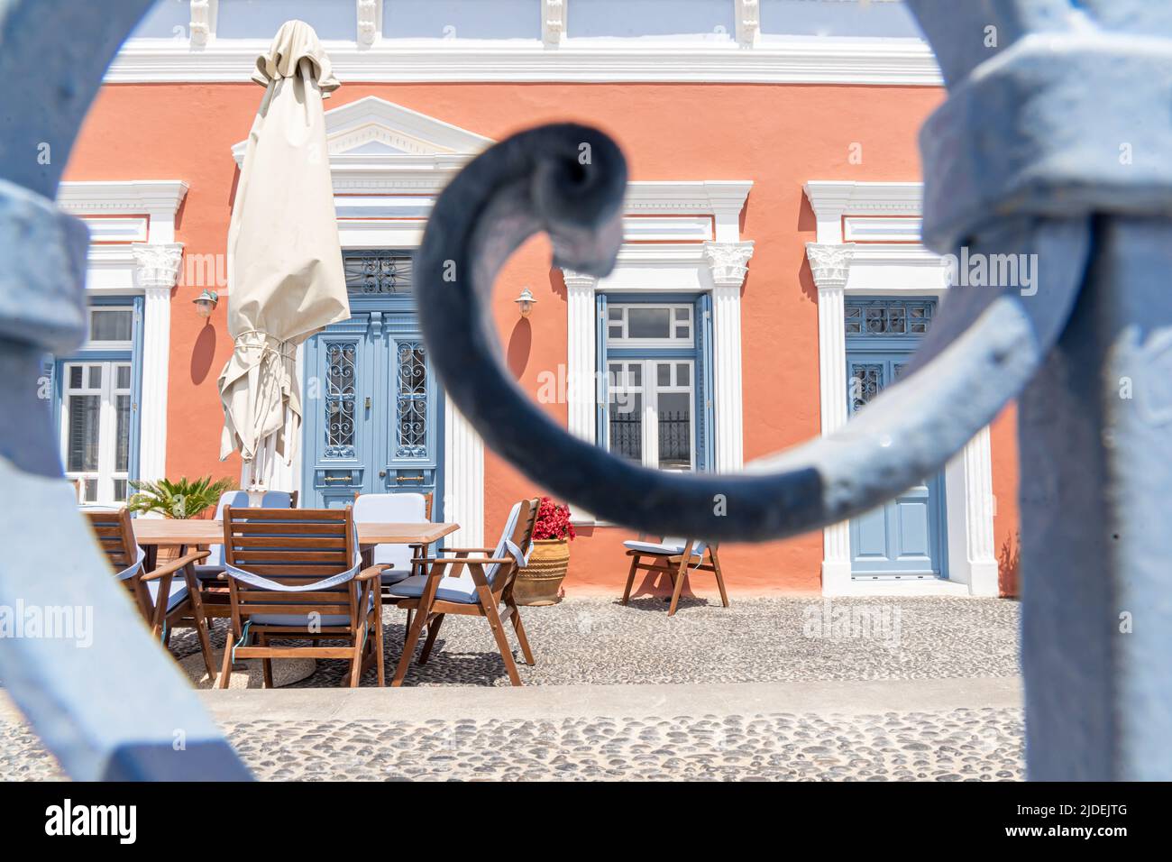 Elegant villa with courtyard seen through a cast iron fence in Oia Stock Photo