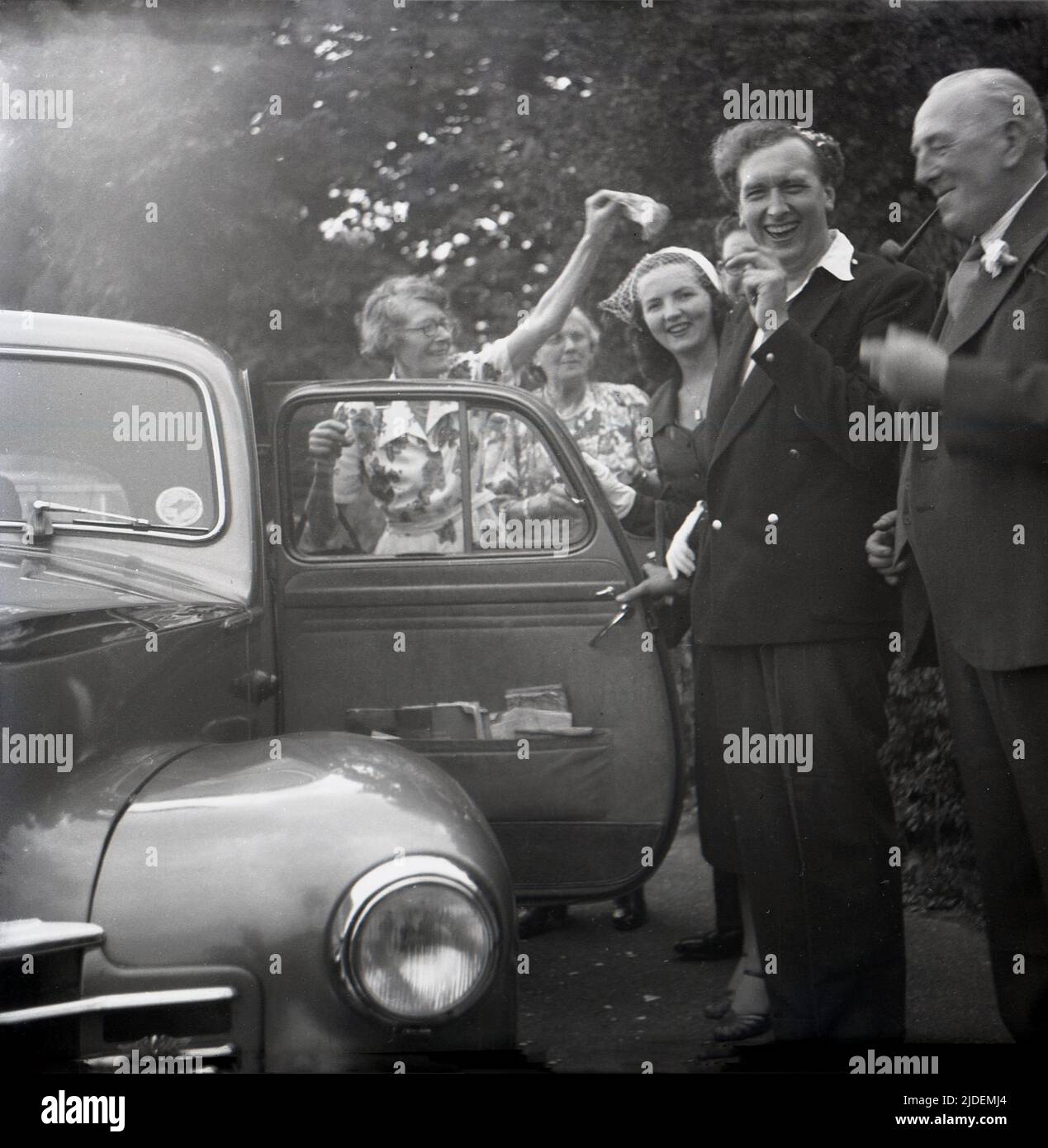 1953, historical, a bride and groom by their wedding car, with a lady