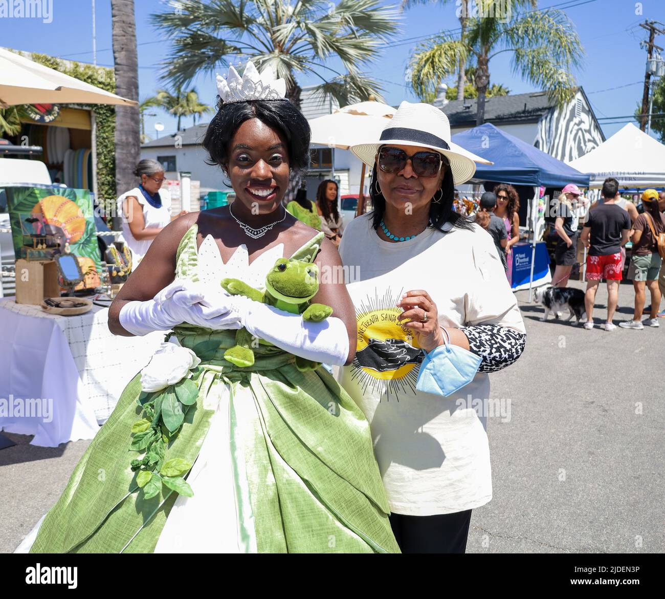Santa Barbara, California, USA. 19th June, 2022. Juneteenth Santa Barbara celebration, at the 200 E. Grey Ave. block, on June 19, 2022. Pictured here as Princess Tiana from Princess and the Frog is Bria Bennett, aka The Chocolate Princess, next to Dianne Travis Teague, Director of Pacifica Graduate Institute's Alumni Relations, one of several sponsors of this year's Juneteenth event. Now an official national holiday in the USA, hundreds were in attendance celebrating the anniversary of the end of slavery, and promoting African American led businesses and non-profit serving the black communit Stock Photo