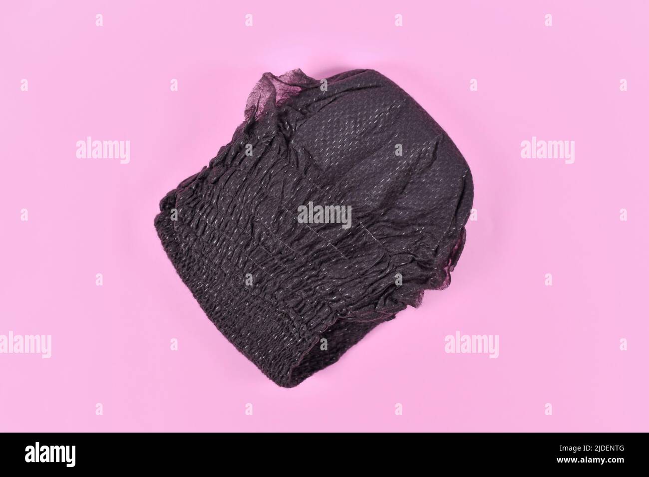 Black folded diaper for adult women on pink background Stock Photo