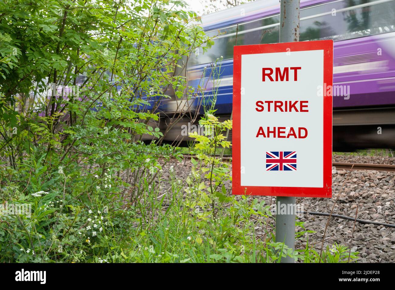 RMT union rail strike ahead sign with speeding train in background. Stock Photo