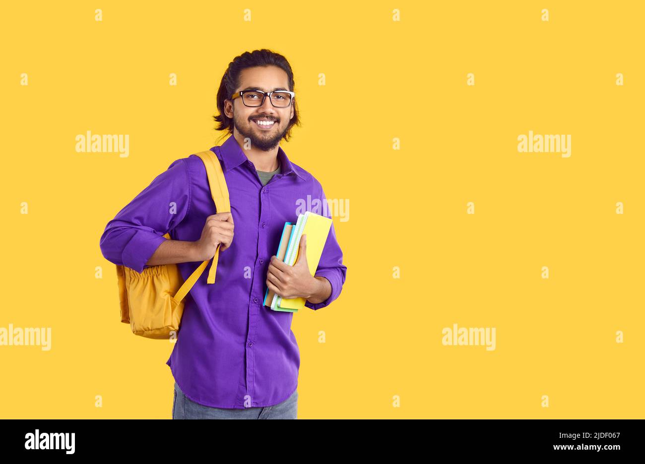 Smiling Indian guy with backpack and books Stock Photo