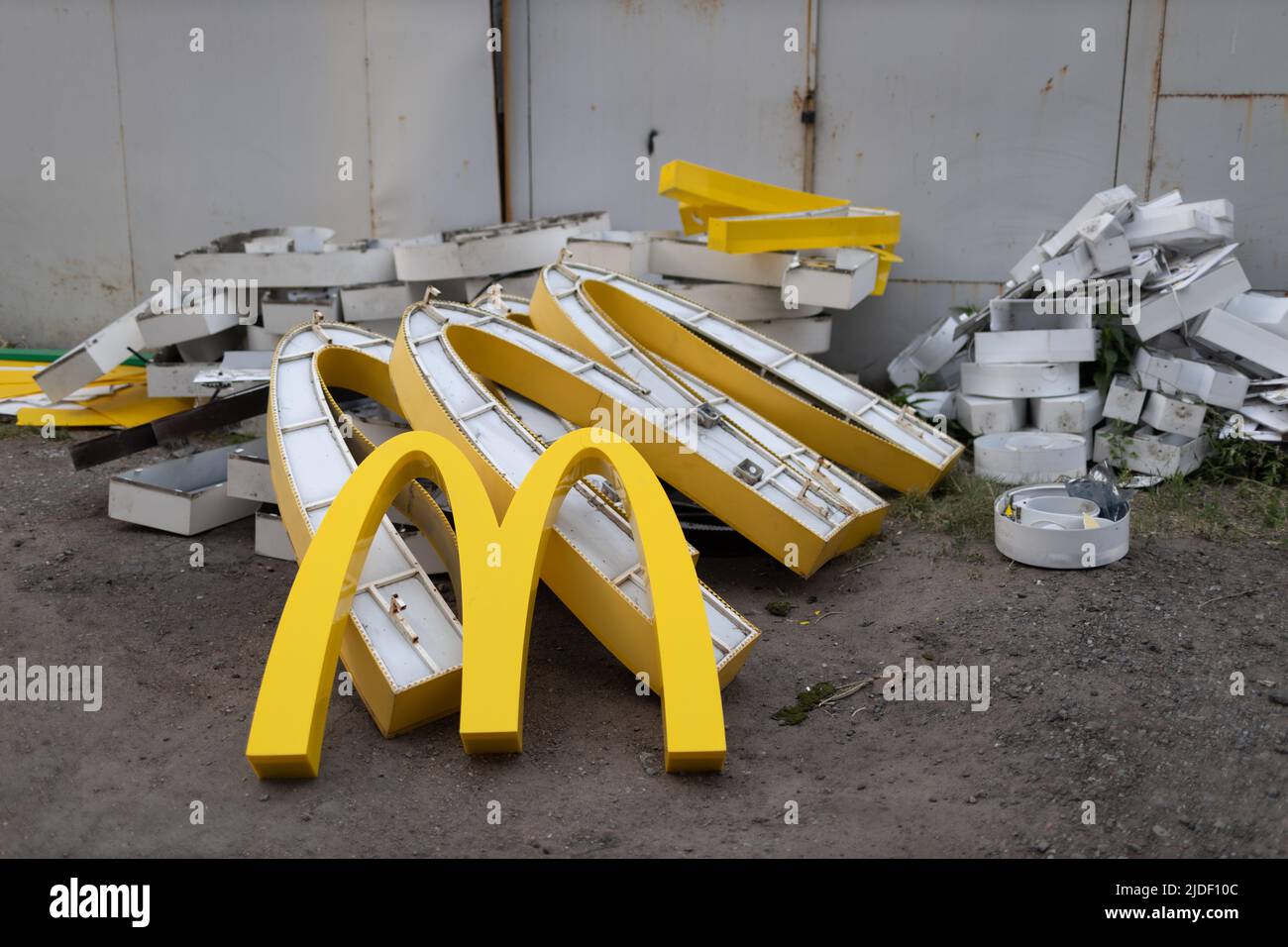 Moscow, Russia - 06.21.2022: McDonalds logo letter character M in dirty rubbish heap dump trash litter garbage. Fast food and sanctions concept. Stock Photo