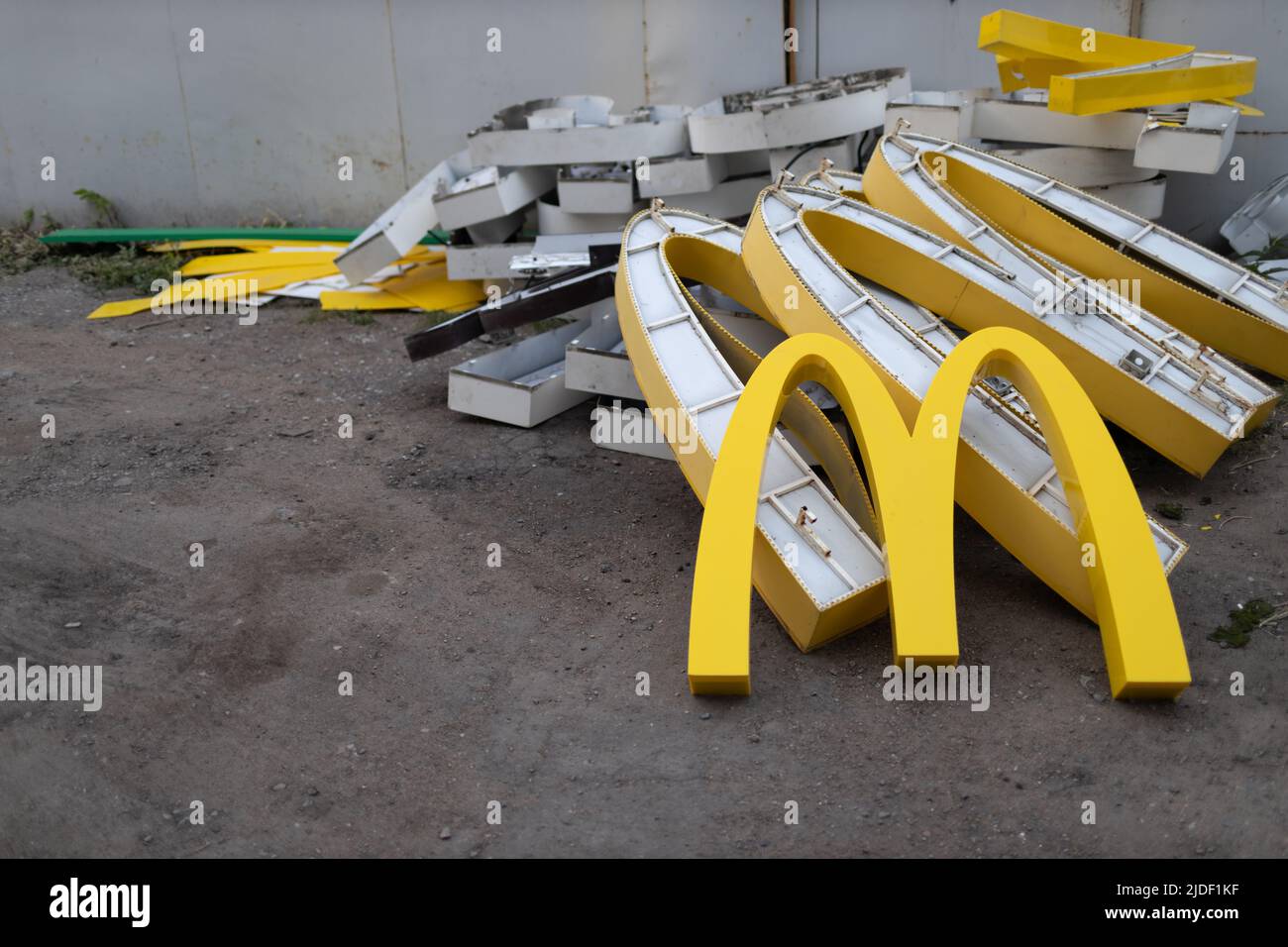 Moscow, Russia - 06.21.2022: McDonalds logo letter character M on dirty rubbish heap dump trash litter garbage. Fast food and sanctions concept. Environment issues Stock Photo