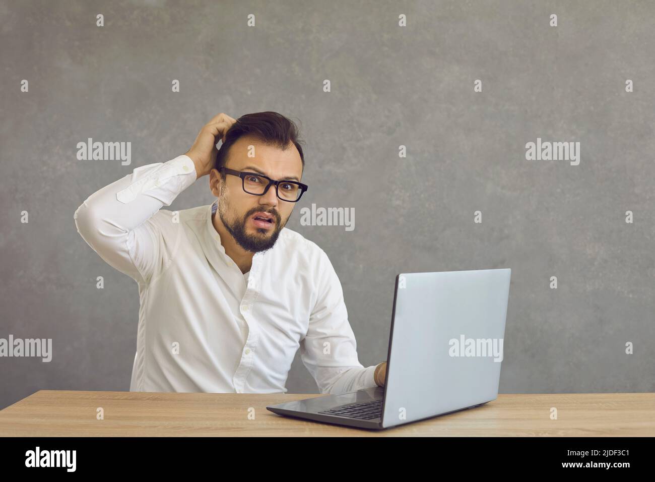 Worried stressed businessman shocked by bad news using laptop studio shot Stock Photo