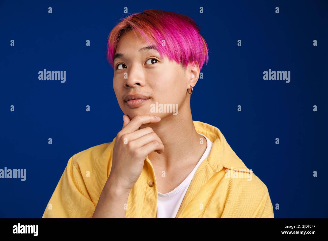 Asian boy with pink hair posing and looking aside isolated over blue  background Stock Photo - Alamy