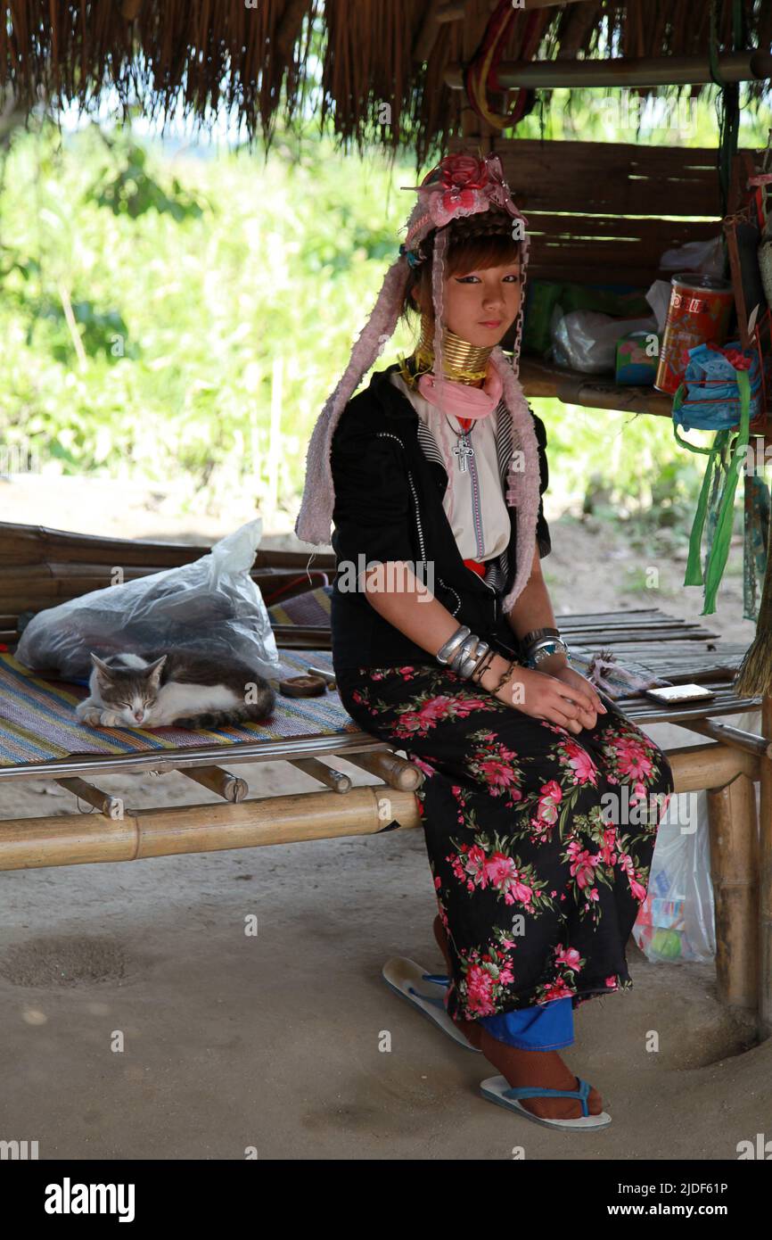 Huai Seau Tao, Thailand - August 04 2012: Smiling young woman of the Kayan Lahwi tribe sitting by her sleeping cat. Stock Photo