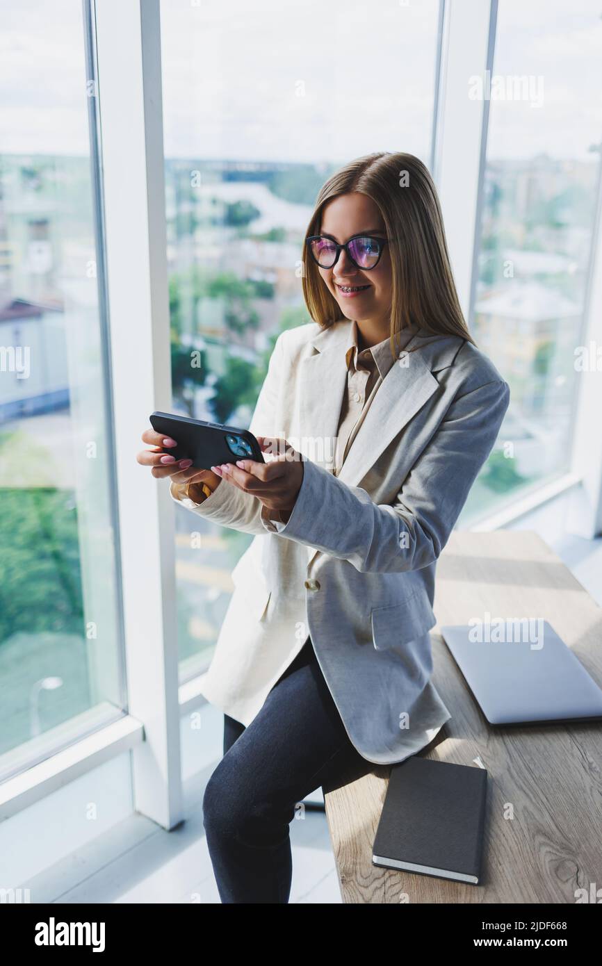 Cheerful young beautiful woman in glasses talking on a mobile phone and ...