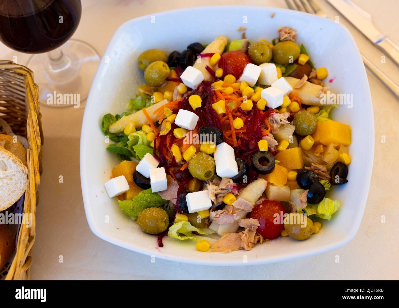Mediterranean tuna salad with vegetables, olives, feta cheese and peach