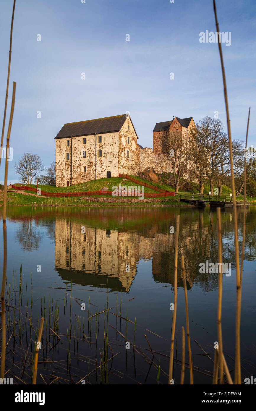 Medieval Kastelholm Castle and its reflections on a calm river in Åland Islands, Finland, on a sunny day in the summer. Stock Photo