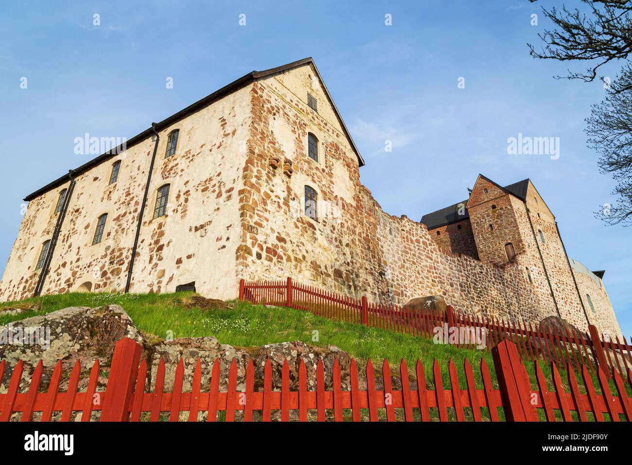 Medieval Kastelholm Castle behind red wooden fence in Åland Islands, Finland, on a sunny day in the summer. Stock Photo