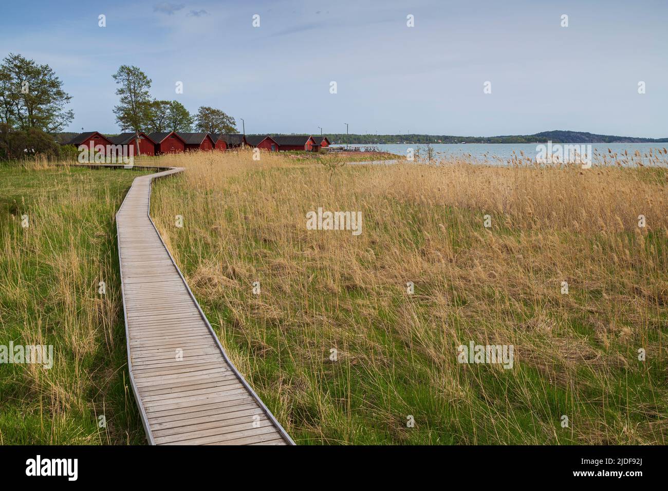 Wooden walkway on a field on the coast in Mariehamn, Åland Islands, Finland, on a sunny day. Stock Photo