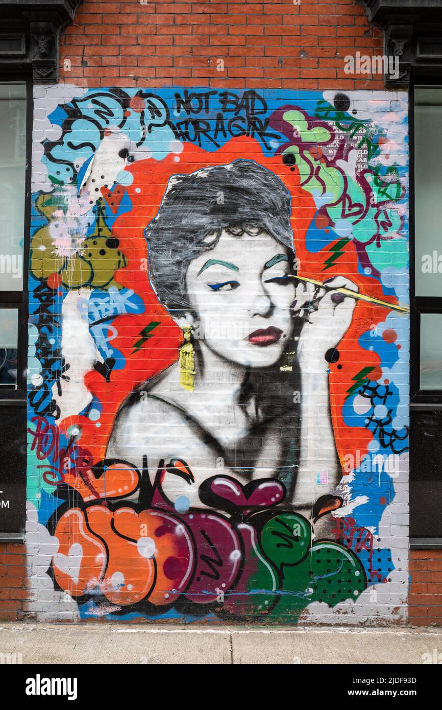 Not Bad for a Girl. Poster and graffiti art by Indie 184 (Soraya Marquez) on the wall of the Ridge Hotel in Lower East Side of Manhattan, NYC, USA. Stock Photo