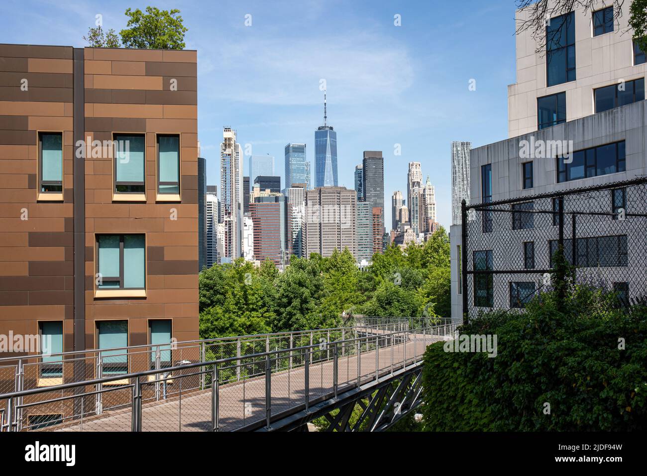 Squibb Park Bridge pedestrian pathway between Brooklyn Heights residential buildings with Lower Manhattan skyscrapers in the background in NYC, USA Stock Photo