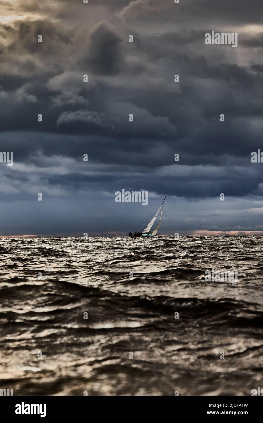 Sailboat in sea at stormy weather, blurred background, stormy clouds ...