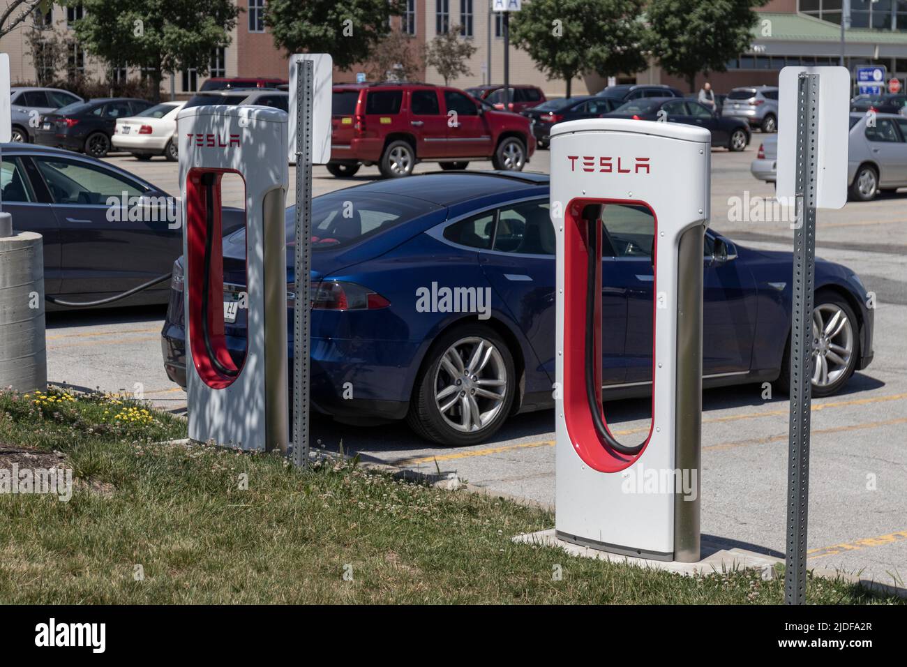 Zionsville - Circa June 2022: Tesla EV electric vehicle charging. Tesla products include electric cars, battery energy storage and solar panels. Stock Photo