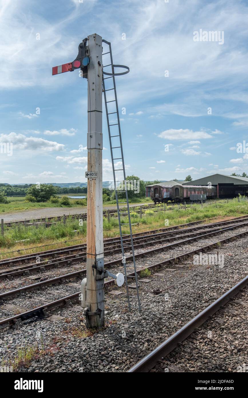 Signal at Hellifield station with a railway shed behind that appears  recently to be housing some old carriages. (maybe for restoration?) June 20th Stock Photo