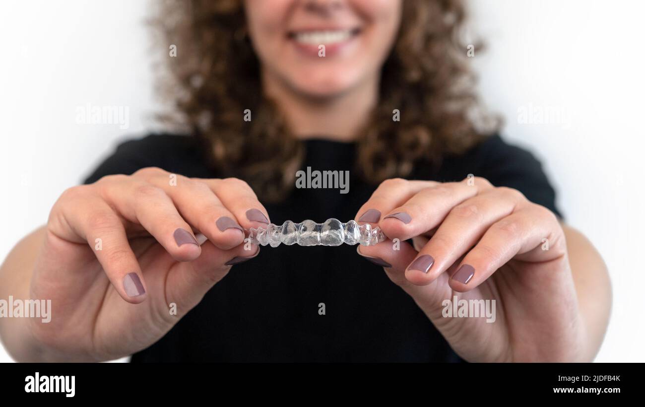Caucasian young woman showing an invisible silicone aligner for dental