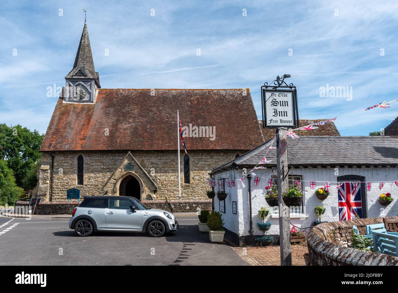Plaistow village in West Sussex, England, UK. View of the village centre with Holy Trinity Church and the Sun Inn pub Stock Photo