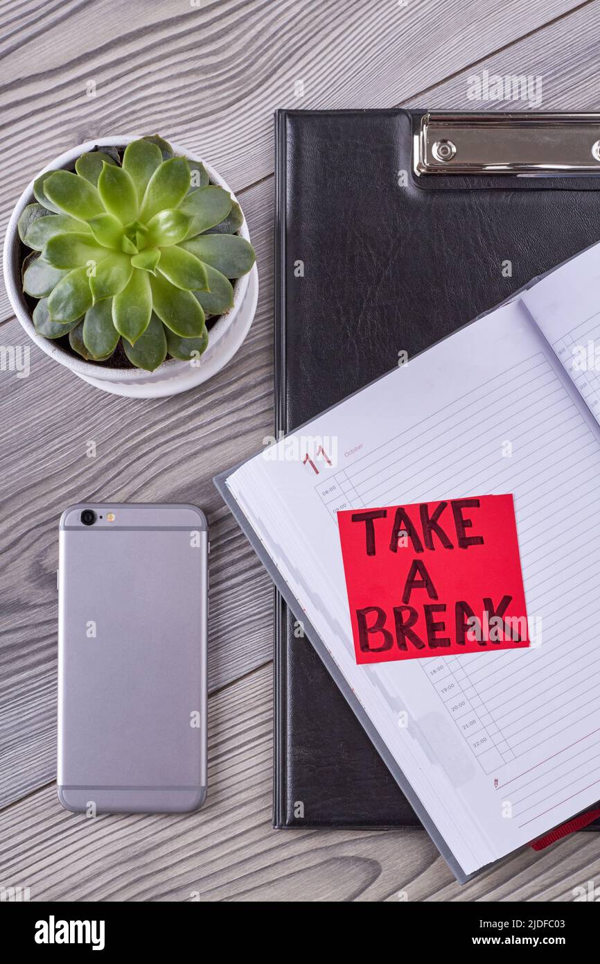 Office desk accessories with smartphone and notepad. Take a break concept. Top view flat lay. Stock Photo