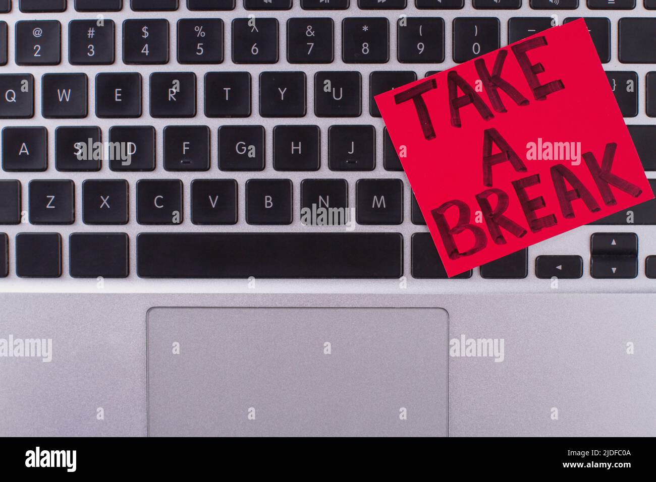Sticker note on laptop keyboard saying take a break. Comfort work place. Stock Photo