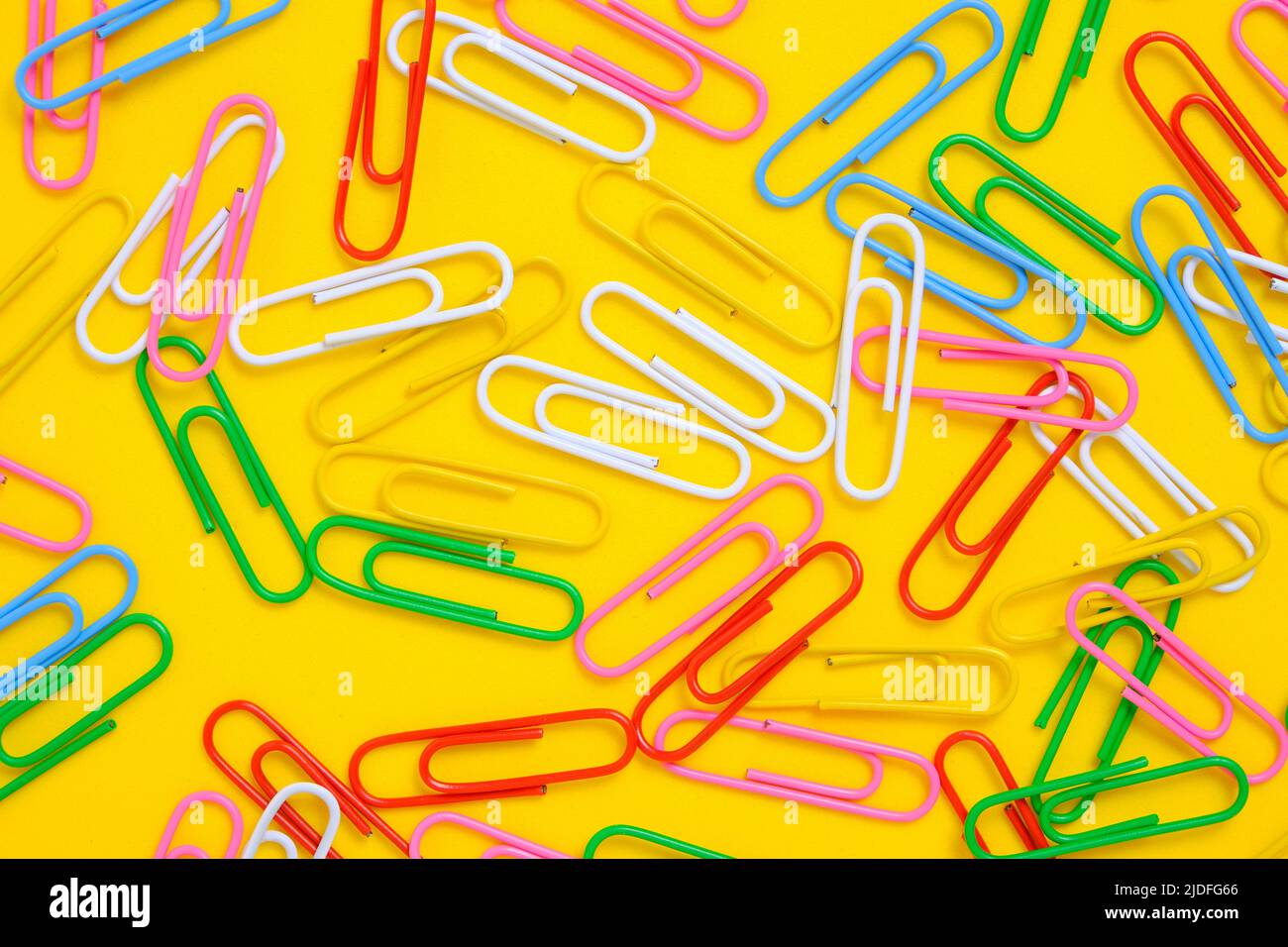 Colored paper clips on a yellow background Stock Photo Alamy