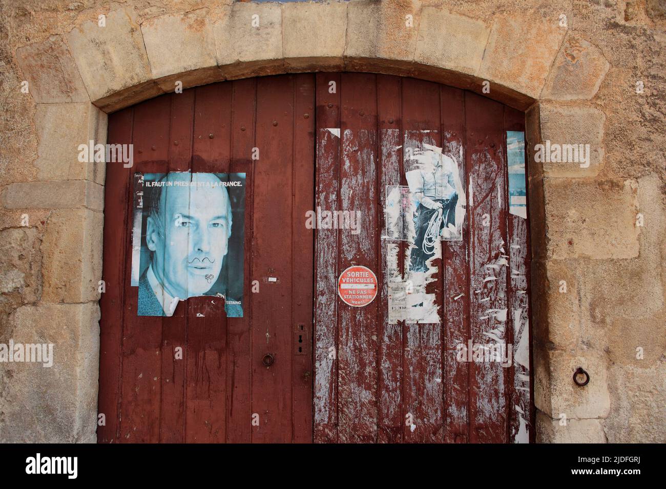 Affiche Valery Giscard d'Estaing 'Il faut un président à la France' avec une moustache sur une porte de garage en bois Stock Photo