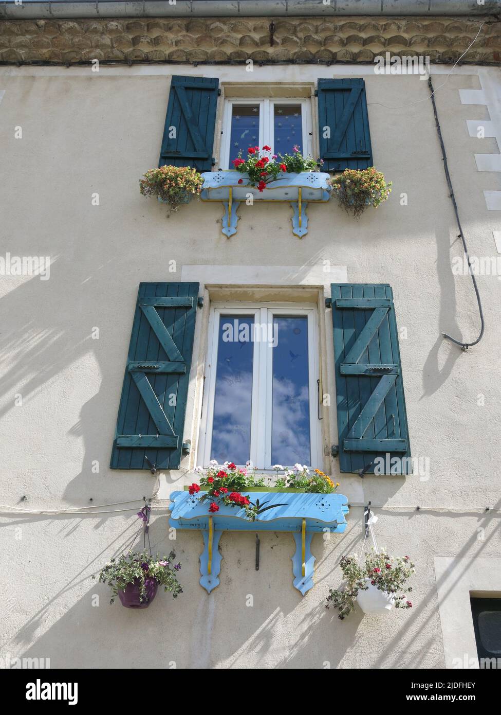 Typical old French house with shutters at the windows and pretty red