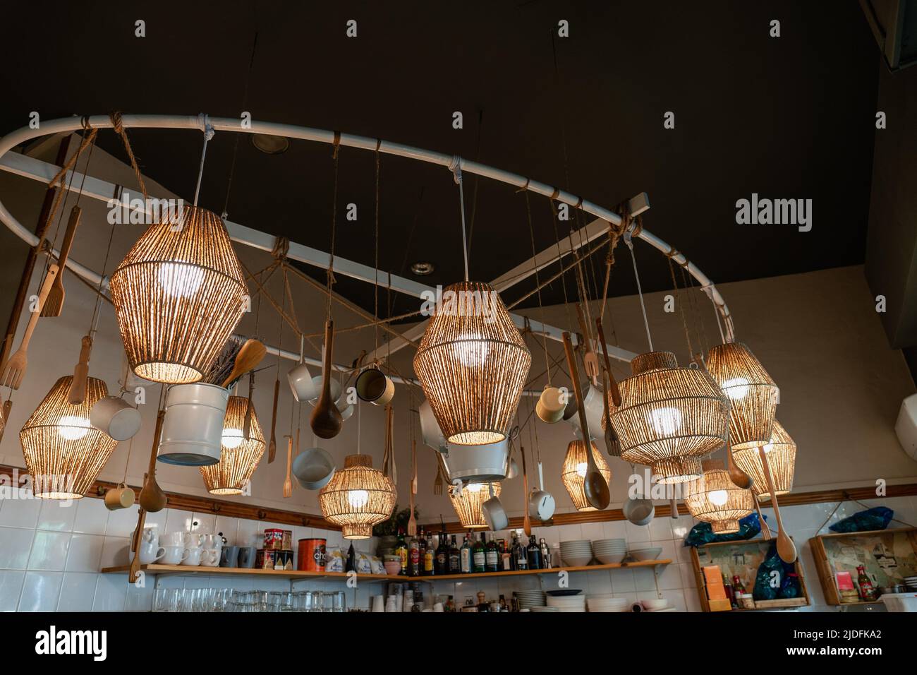 Wicker lamp shades hanging from a ceiling in a cafe. Counter in a