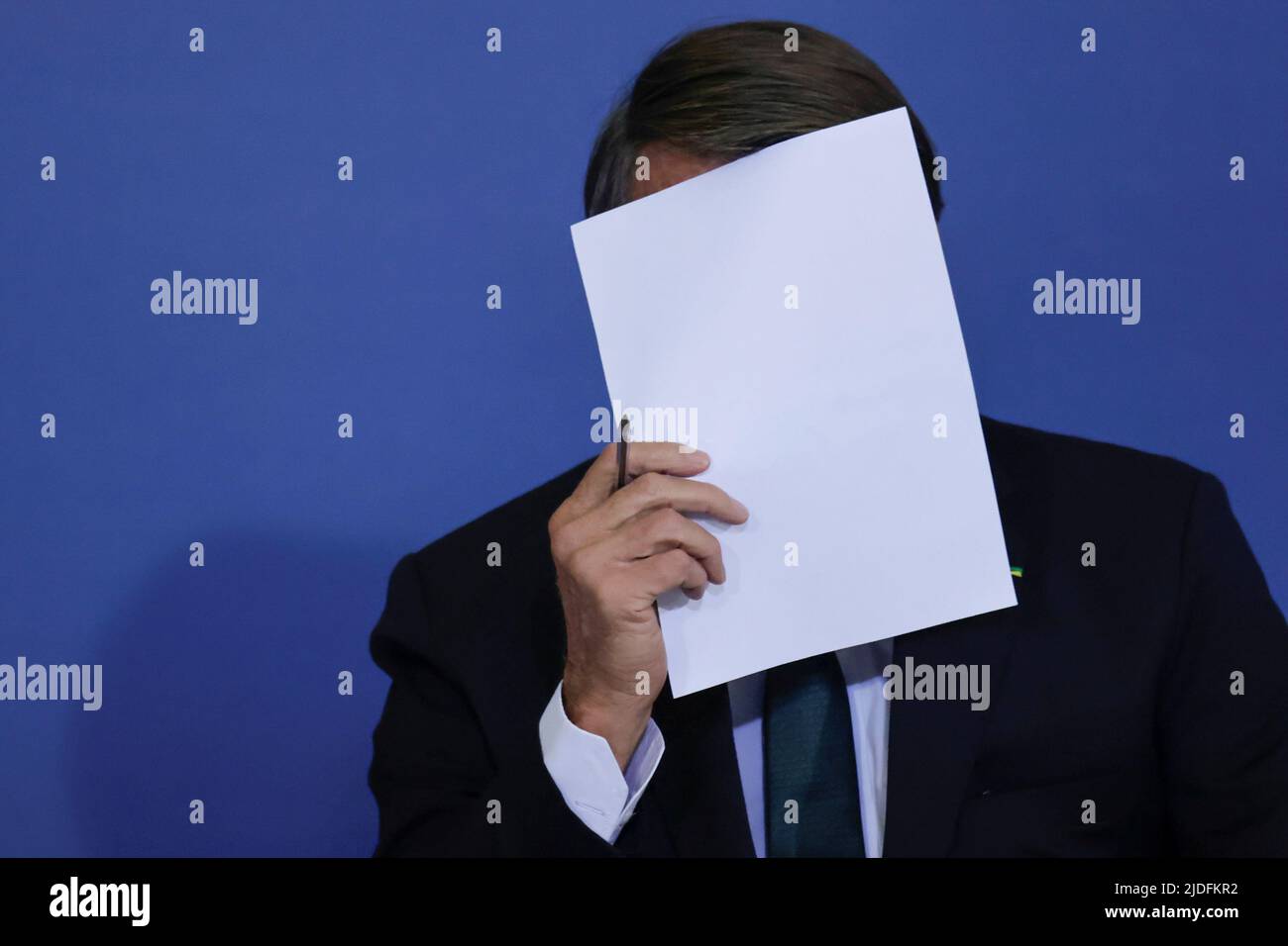 Brazil's President Jair Bolsonaro puts a sheet of paper in front his face during a ceremony about the National Policy for Education at the Planalto Palace in Brasilia, Brazil June 20, 2022. REUTERS/Ueslei Marcelino Stock Photo