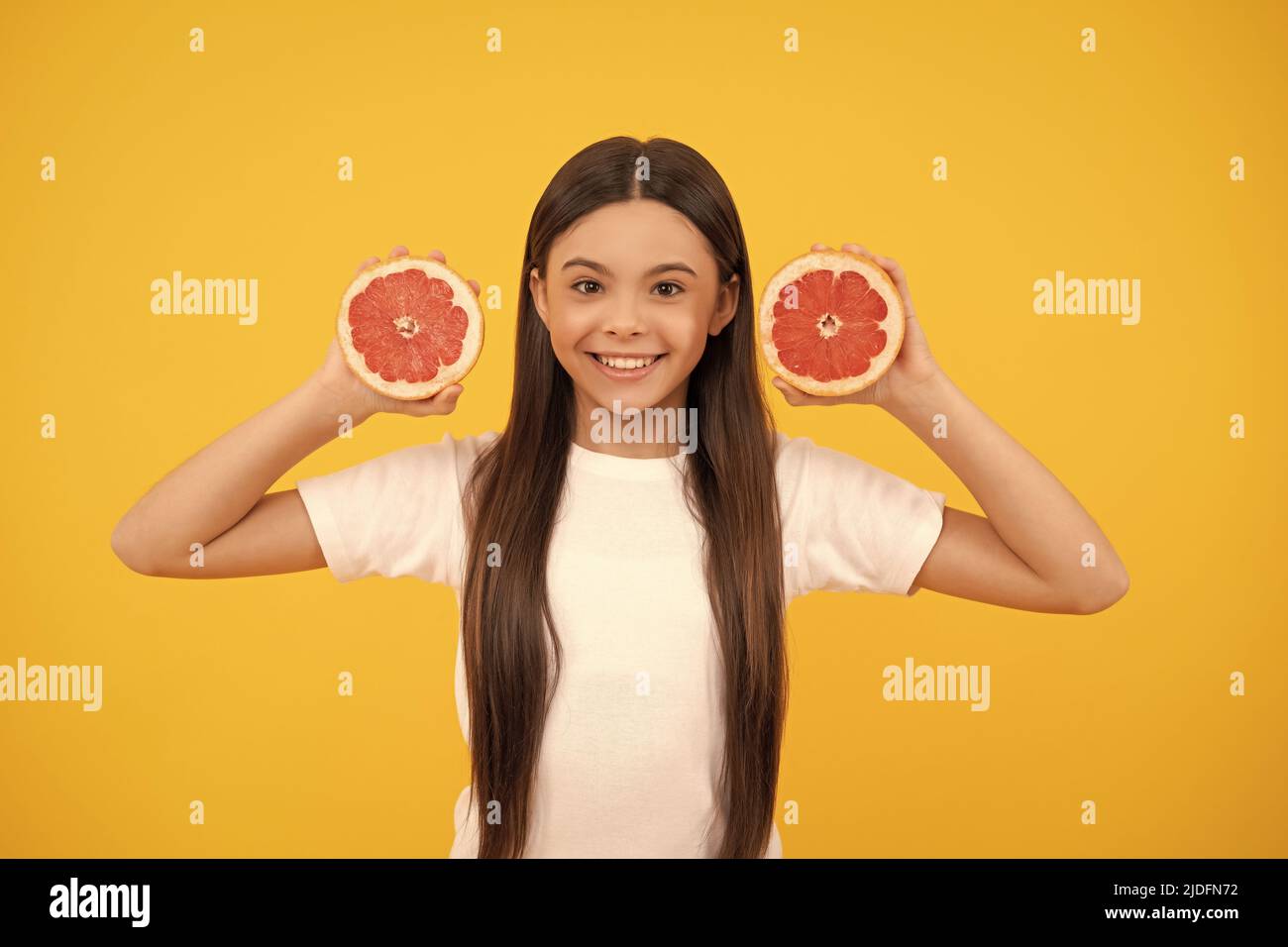 happy teen girl with grapefruit on yellow background, diet Stock Photo