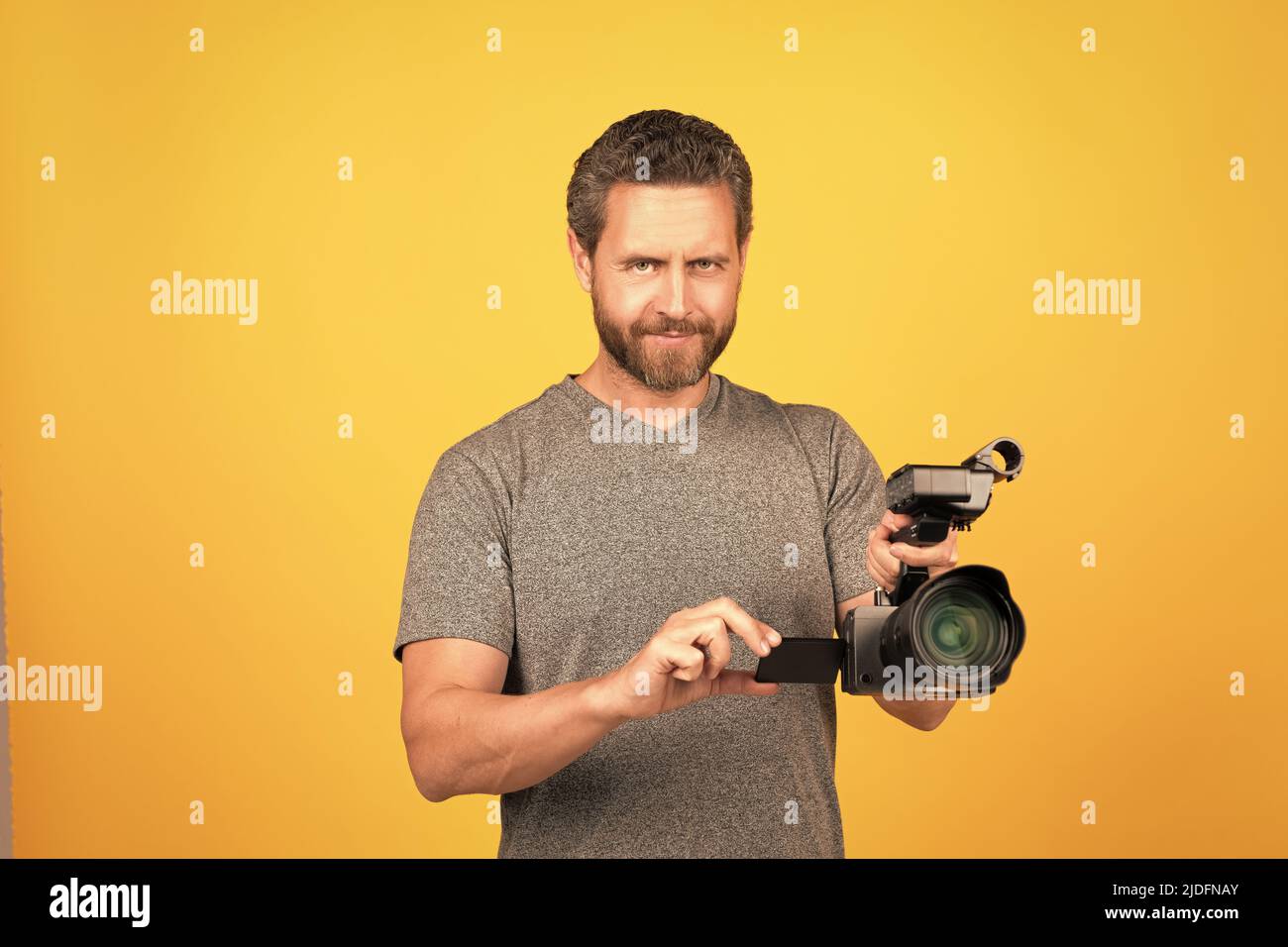 smiling bearded man videographer making movie for vlog with camcorder, cinematographer Stock Photo
