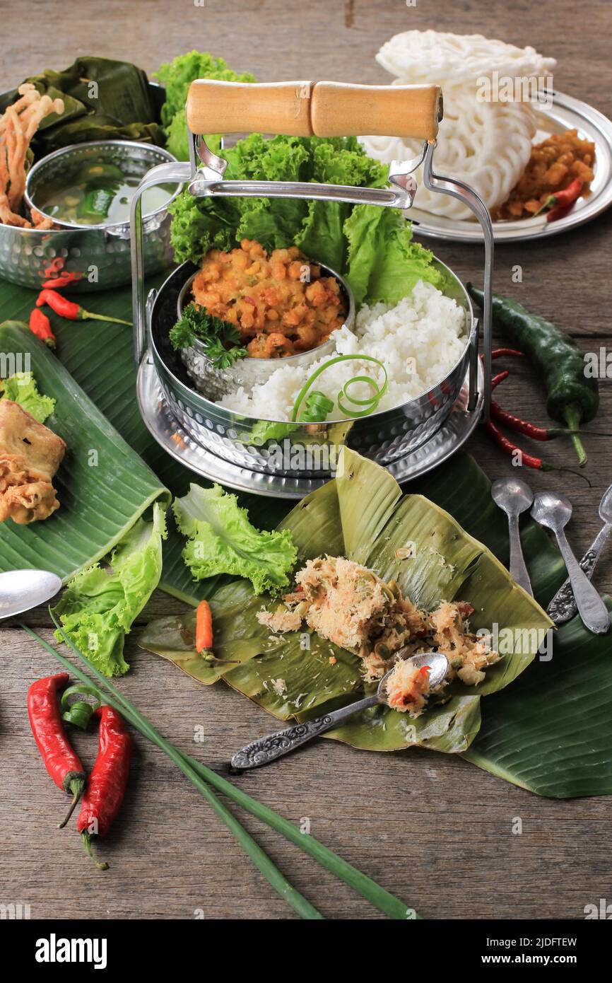 Indonesian Traditional Food for Daily Menu, Served using Rantang (Stackable Rice Box). White Rice, Spinach Soup, Corn Fritter, Bothok Mlandingan, and Stock Photo