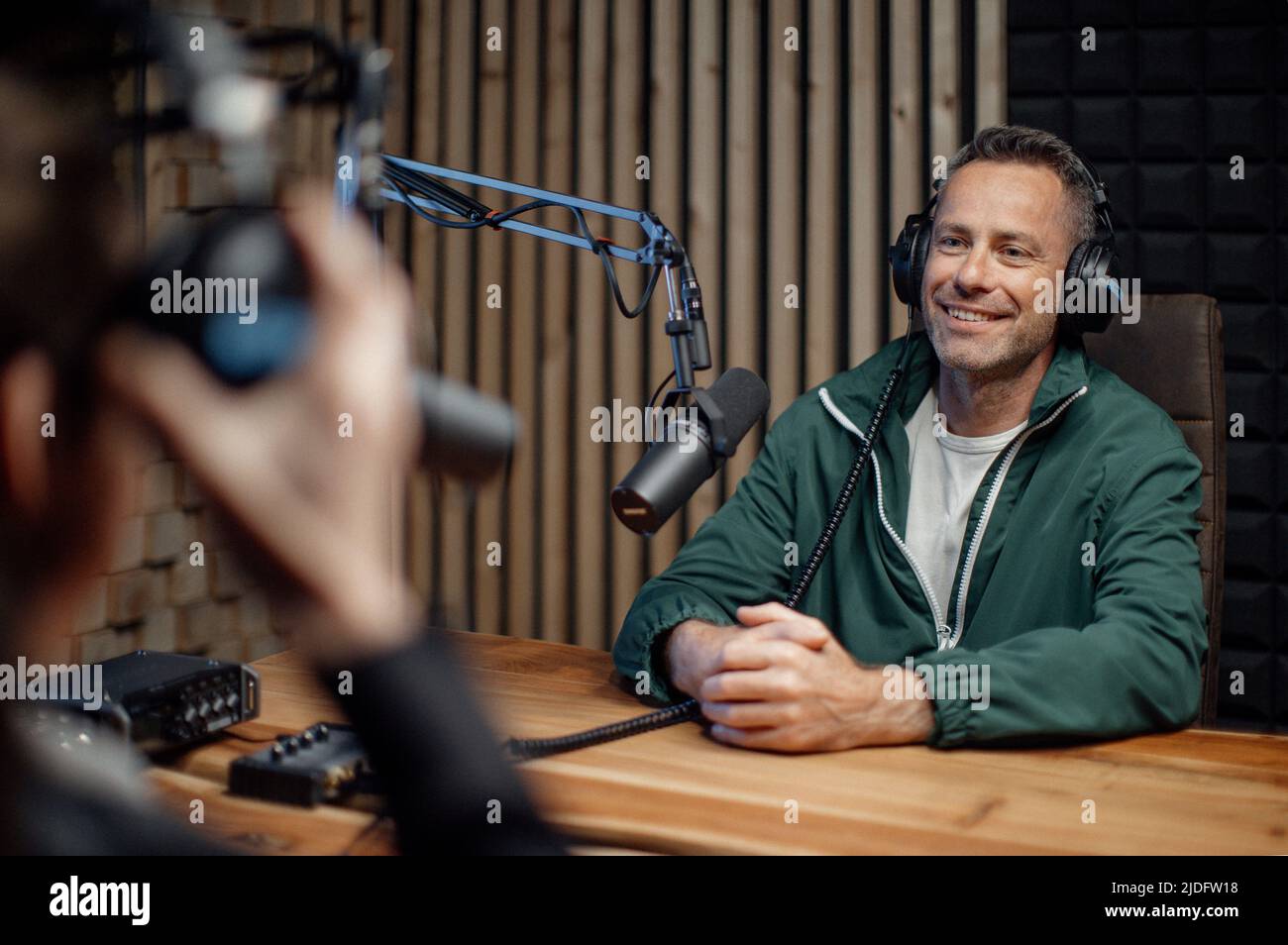 Man host talking to microphone and interviewing a man for a radio podcast. Stock Photo
