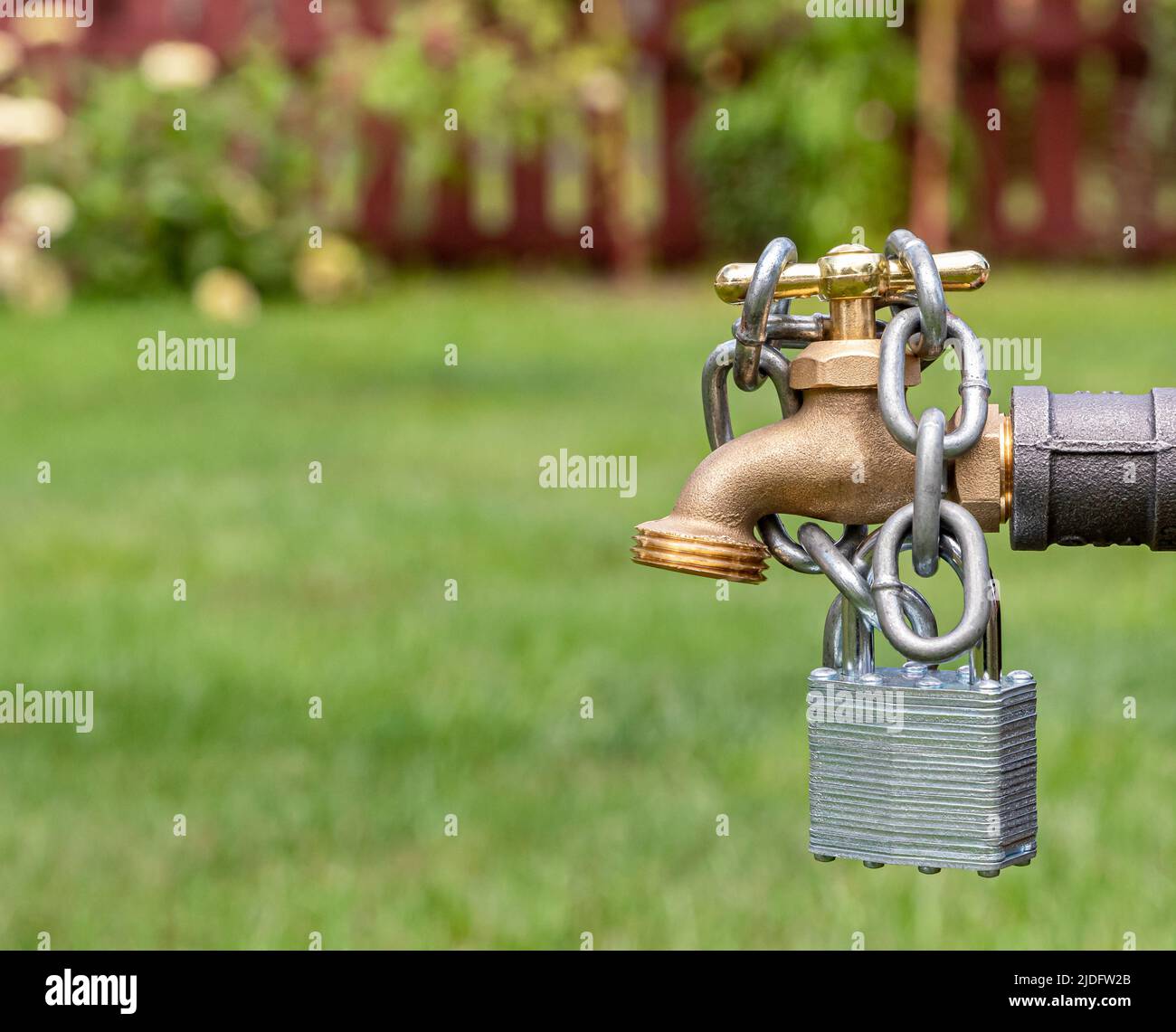 Outdoor water faucet with lock and chain. Water restriction, supply and shortage concept Stock