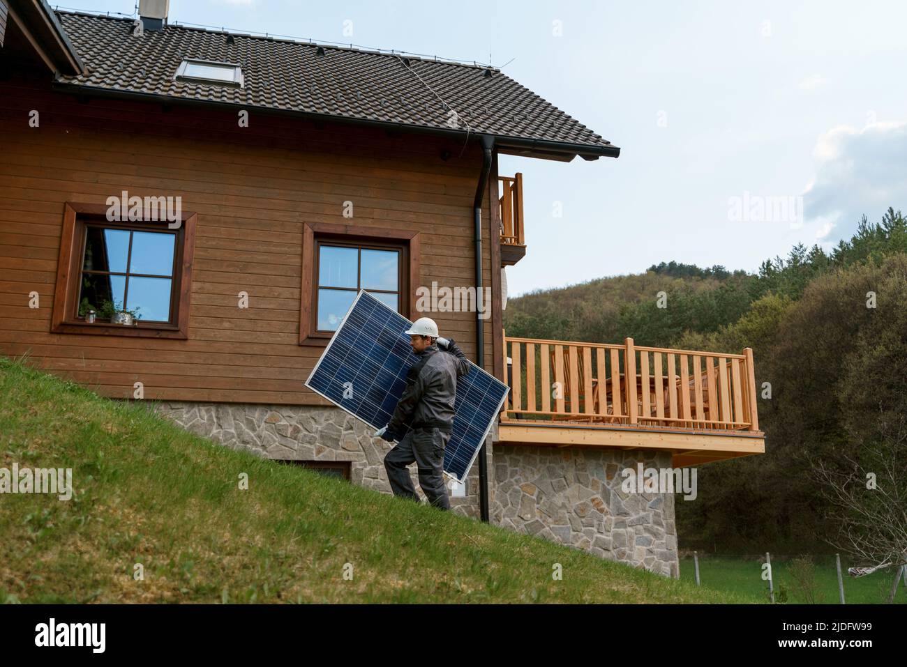 Man worker carrying solar panel for installing solar modul system on house. Stock Photo