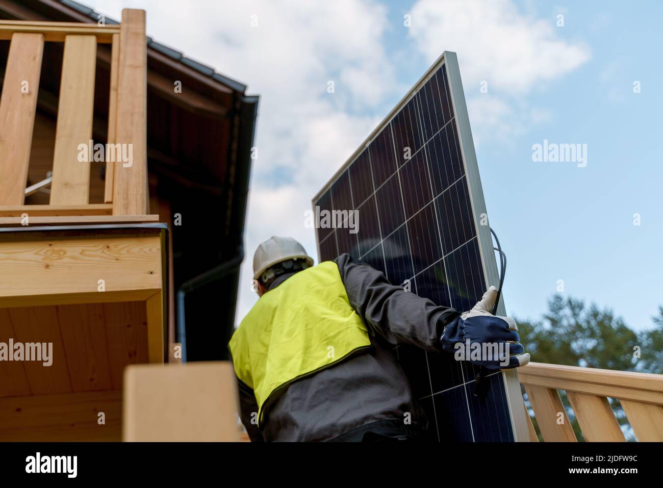 Man worker carrying solar panel for installing solar modul system on house. Stock Photo