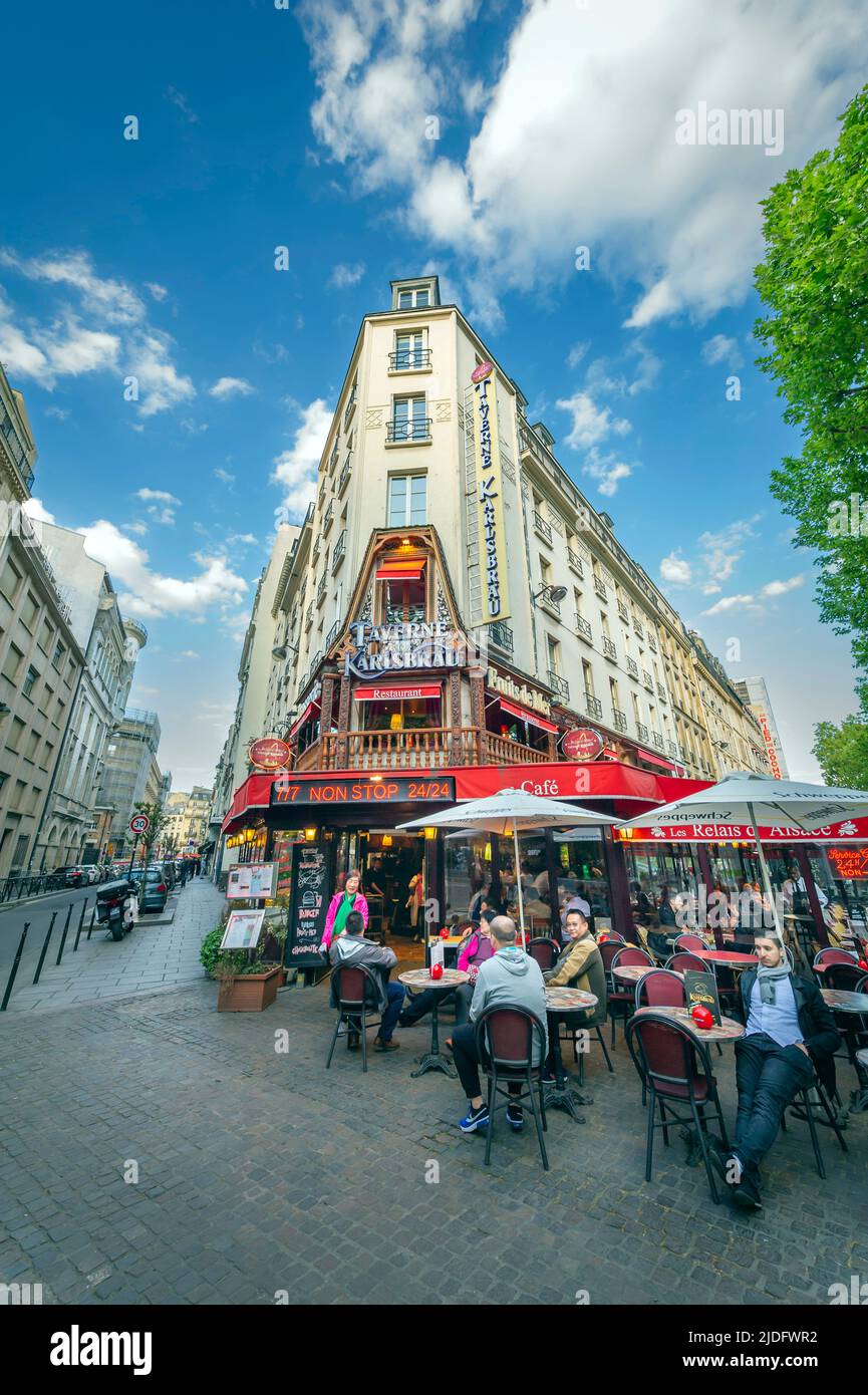 People dining out on an open patio of a typical Parisian restaurant Stock Photo